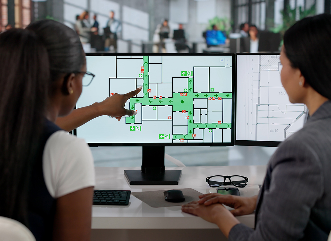 coworkers review building emergency map on screen
