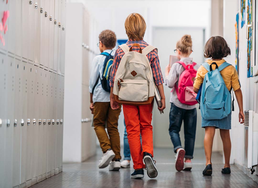 kids-with-backpack-walk-down-school-hallway